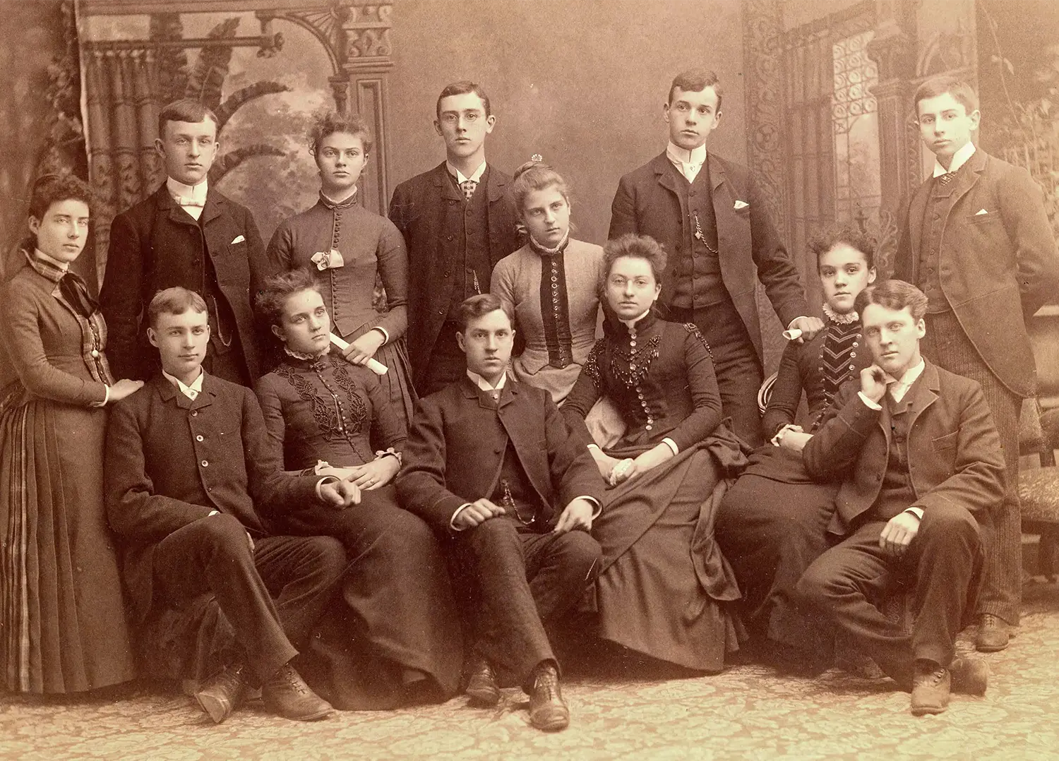 A group photo of men and women dressed in Victorian-era formal attire.